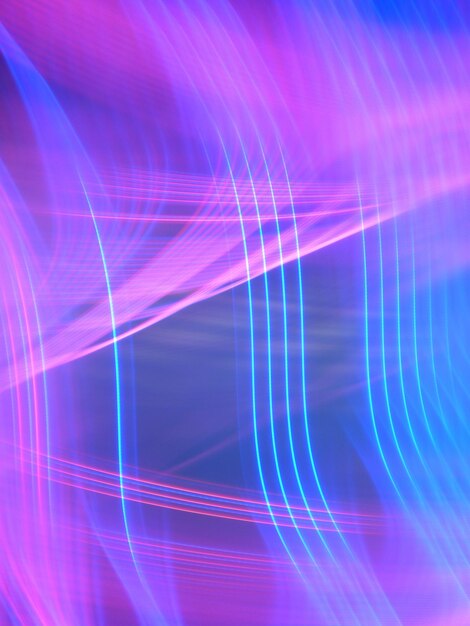 Close-up of light trails over colored background