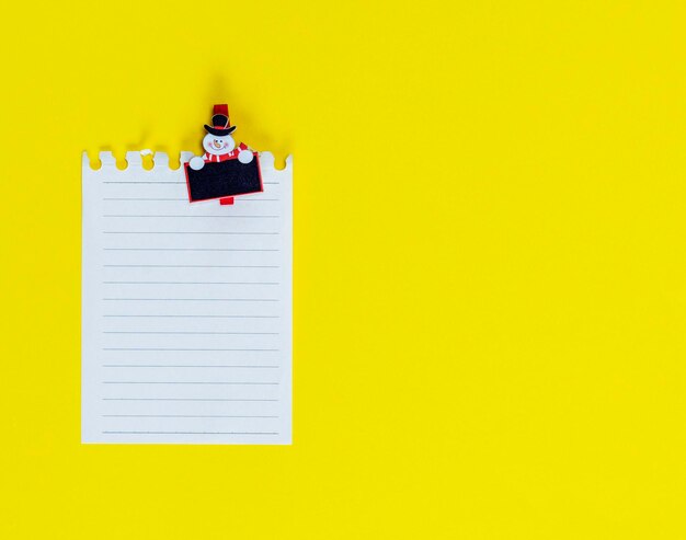 Close-up of lined paper and toy on yellow background