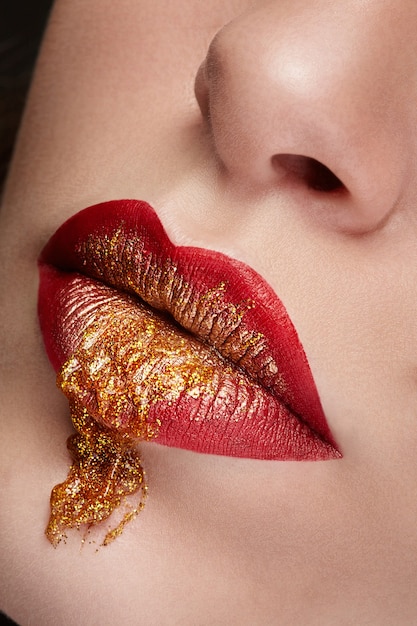 Photo close up lips with red and gold make up in studio photo