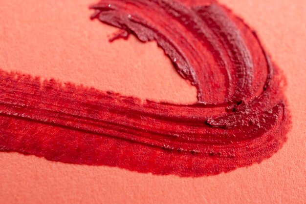 Photo close up of a lipstick smudged on a red background