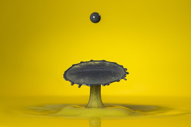 Close-up of liquid splashing against yellow background