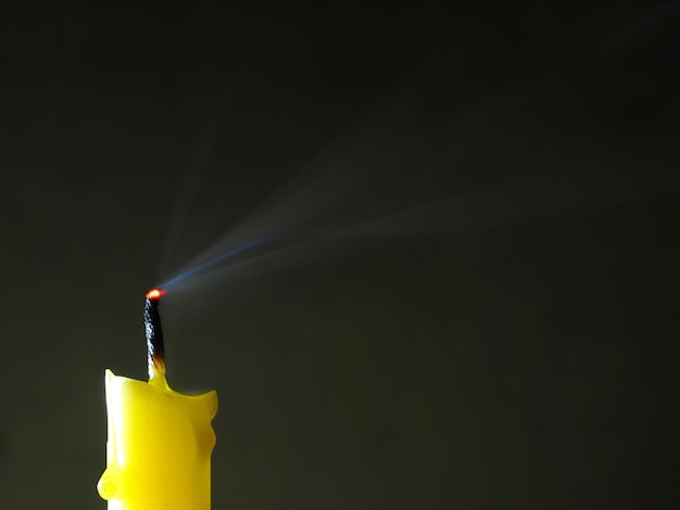 Photo close-up of lit candle against black background