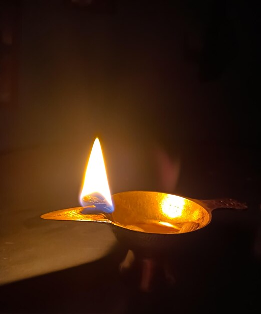 Close-up of lit candle in the dark