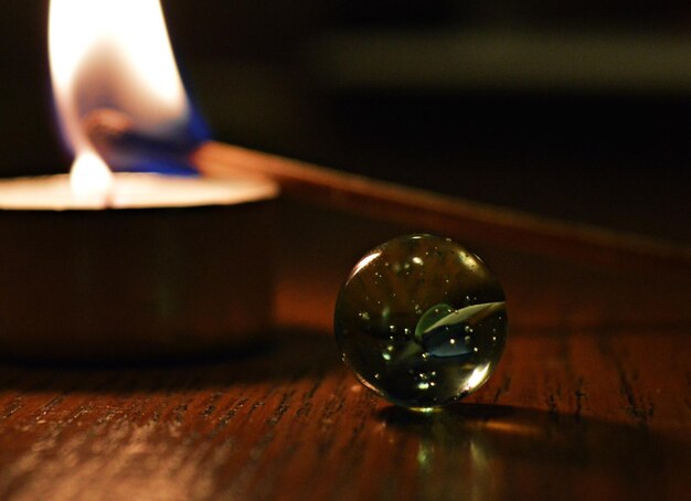 Close-up of lit candle on table