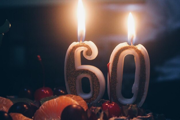 Foto close-up di candele accese sulla torta di compleanno 60 anni
