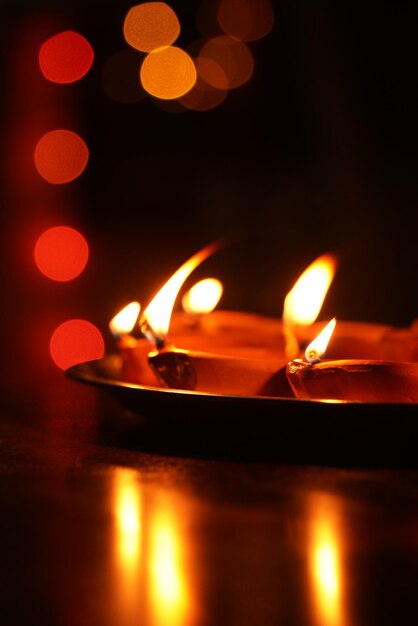 Close-up of lit candles burning in the dark