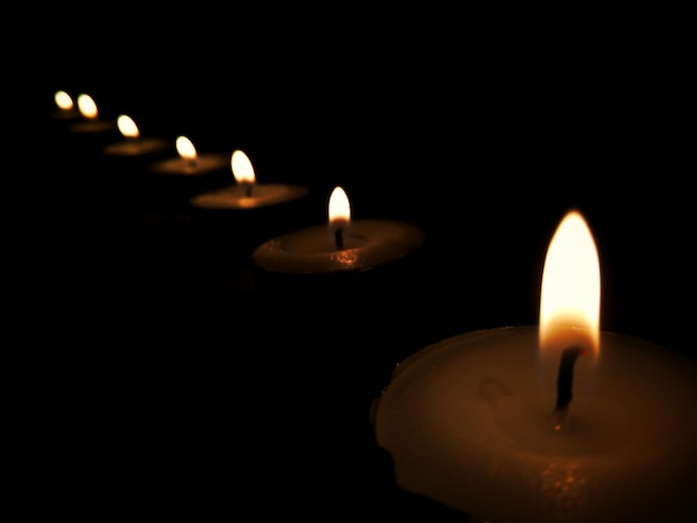 Close-up of lit candles in darkroom