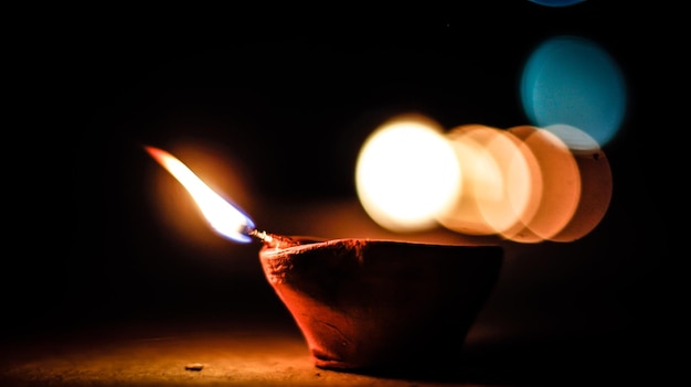 Photo close-up of lit diya at night