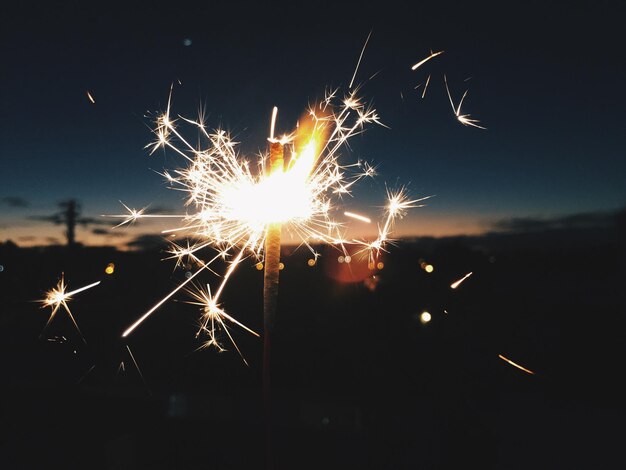 Photo close-up of lit sparkler at night