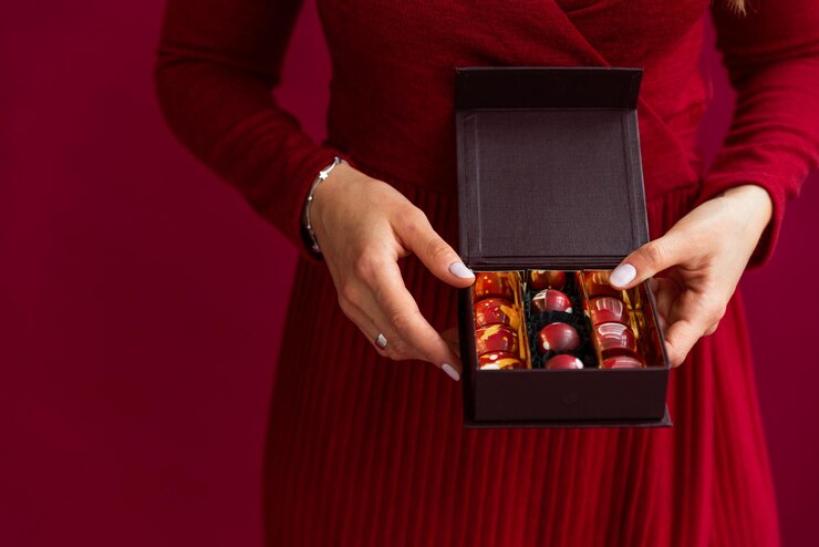 Close up of little box of bonbons in female hands Female taking chocolate candy in little box