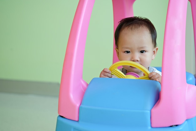 コピースペースでプラスチック車で運転する小さな男の子を閉じます。