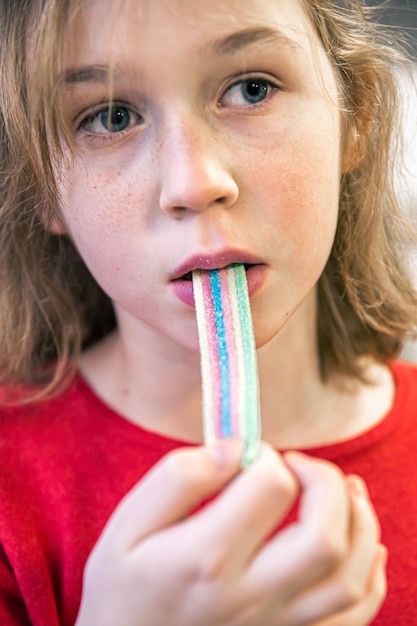 Close up little girl eating gummy candy