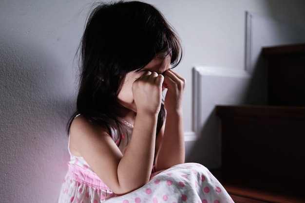 Close up little girl start to cry at staircase