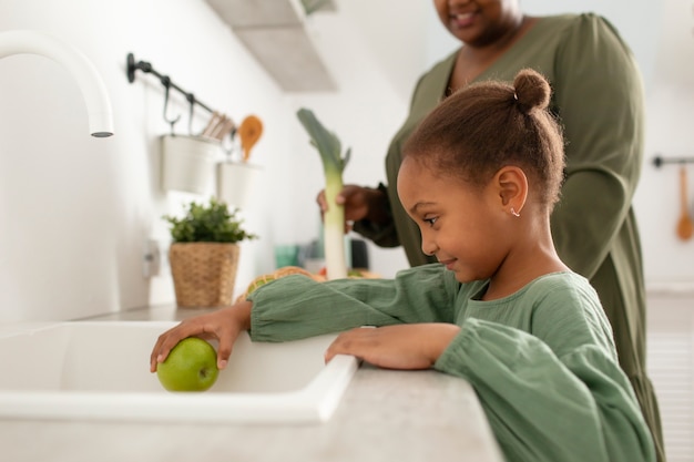 Photo close up little girl washing apple