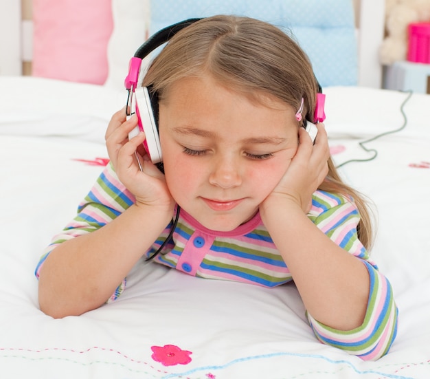 Close-up of a Little gril listening to music with headphones 