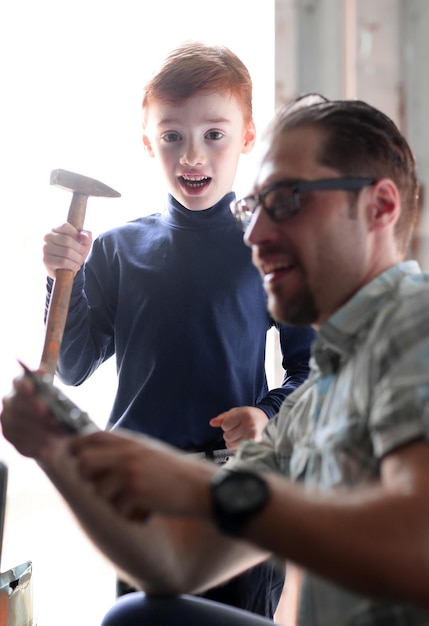 Close up the little son helps his father to make repairs