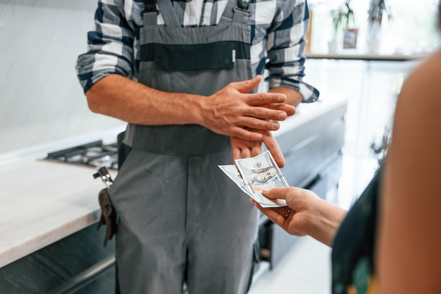 Close-up loodgieter ontvangt contant geld voor het werk dat hij in de keuken doet