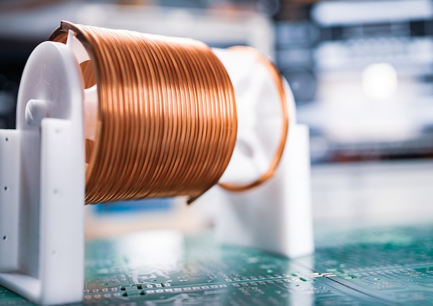 Photo close-up a lot of skeins of twisted copper wire are standing on a green microcircuit.