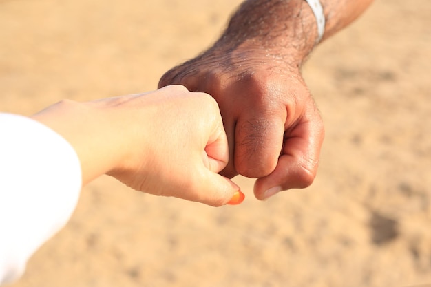 Close up of love couple holding hands on the sea beachclose up