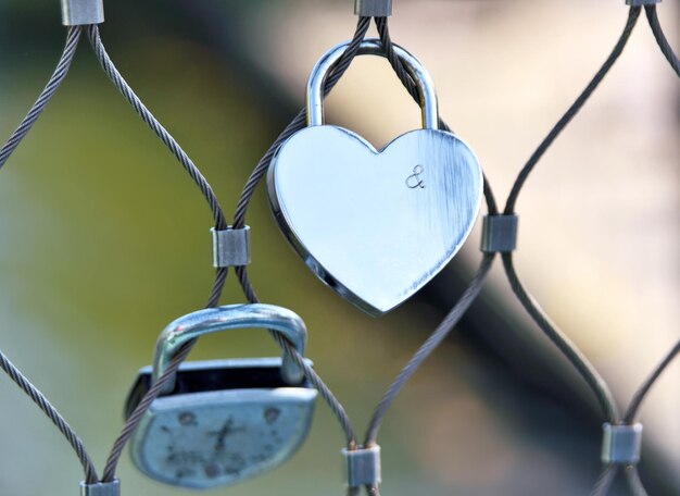 Foto close-up di lucchetti d'amore appesi alla recinzione