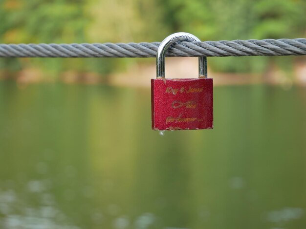 Close-up of love padlocks hanging on metal fence