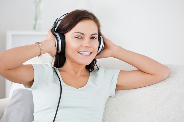 Foto chiuda in su di un brunette adorabile che ascolta la musica