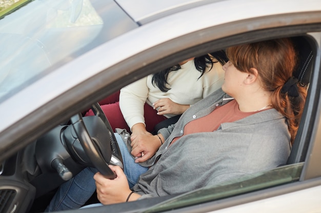 Foto primo piano di bella coppia lesbica mano nella mano durante il loro giro in auto