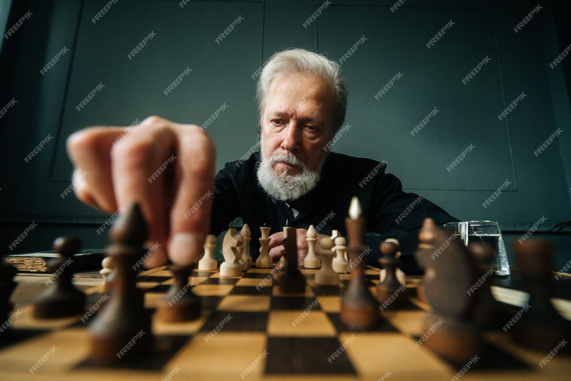 Serious man playing chess in studio · Free Stock Photo