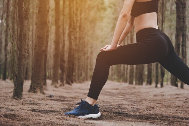 Close up of lower body of woman doing yoga and stretching legs 