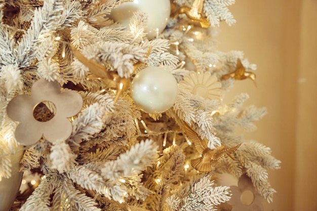 Photo close up luxury gold and silver ball baubles decoration hanging on the white pine christmas tree winter holidays background magic timeelegant tree with white toys in luxury apartments