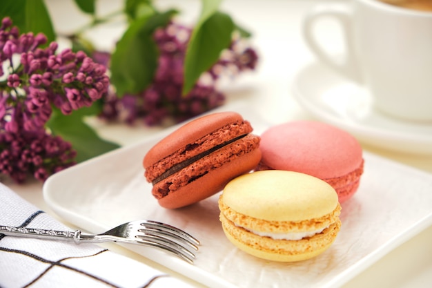 Close-up macarons en kopje koffie met op een tafel met lila bloemen