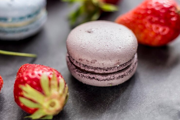 Photo close-up of macaroons and strawberries on table