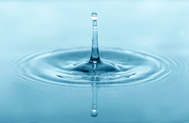 Close-up macro picture of drop on water surface, water drops splash as background