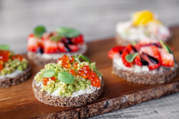 Close-up macroreeks verschillende noordelijke trendy voorgerechten op het brood van de smorrebrodrogge.