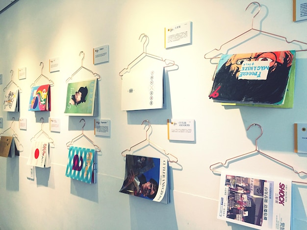 close-up of magazines hanging on coathanger on wall