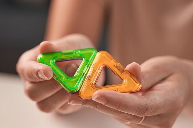 Close up of magnetic building toy. WOman playing with preschooler.