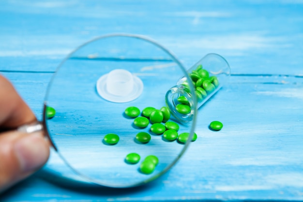 Close-up of a magnifying glass and pills scattered on the table