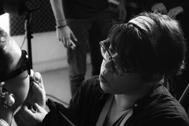 Photo close-up of make-up artist applying lipstick on woman