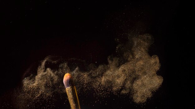 Photo close-up of make-up brush against black background