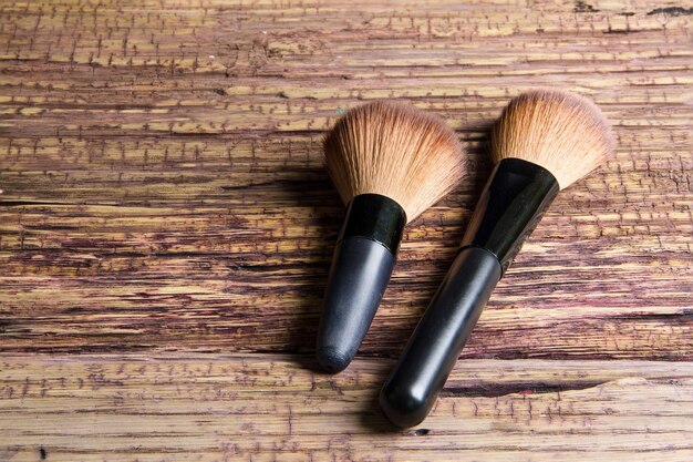 Photo close-up of make-up brushes on wooden table