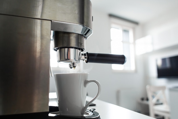 Foto primo piano di produrre caffè in una macchina da caffè.