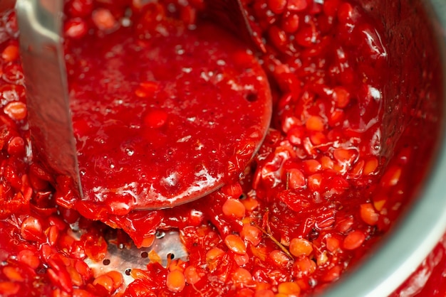 Close up of making jam and separating seeds from guelder rose berries Guelder berries jam making