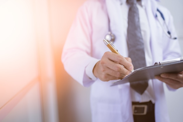 Close-up Of Male Doctor Filling The Medical Form