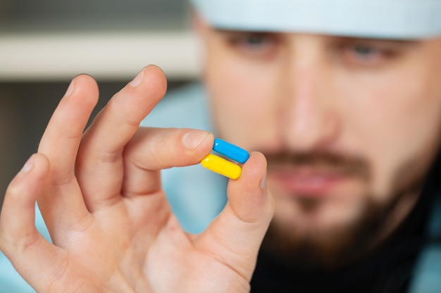 Close-up of male doctor holding pill for men health