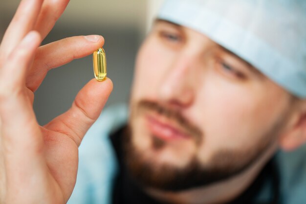 Close up of male doctor holding pill