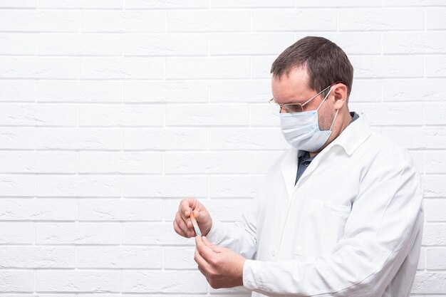 Close up male doctor holding syringe