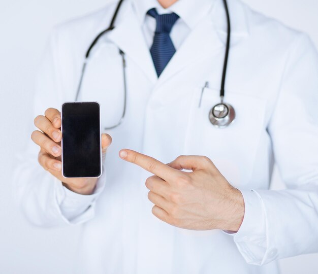 Photo close up of male doctor pointing at smartphone