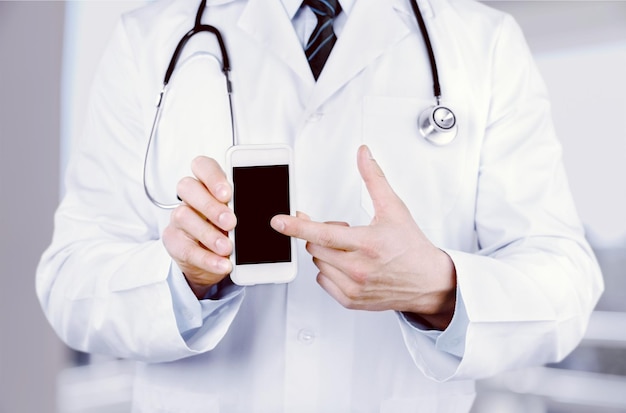 Close-up of male Doctor pointing at smartphone