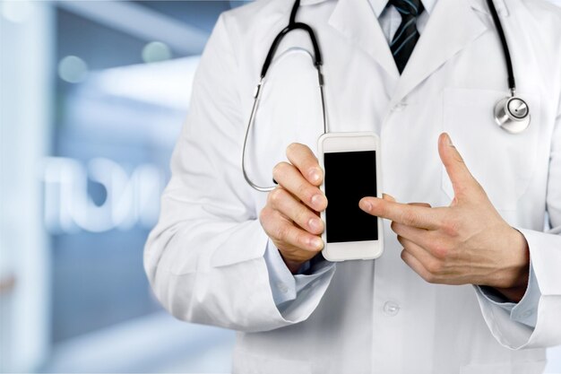 close up of male doctor pointing at smartphone