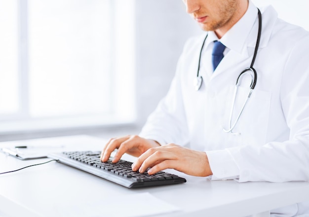 close up of male doctor typing  on the keyboard